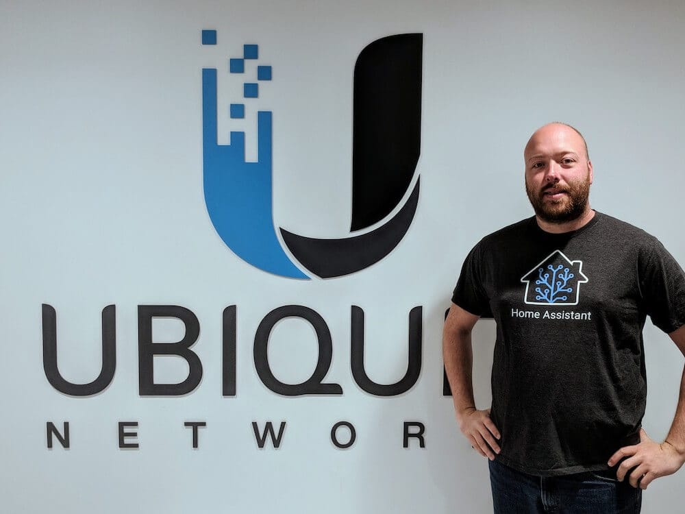 Photo of Paulus, the founder of Home Assistant, standing in front of a Ubiquiti Networks logo wearing a Home Assistant t-shirt.